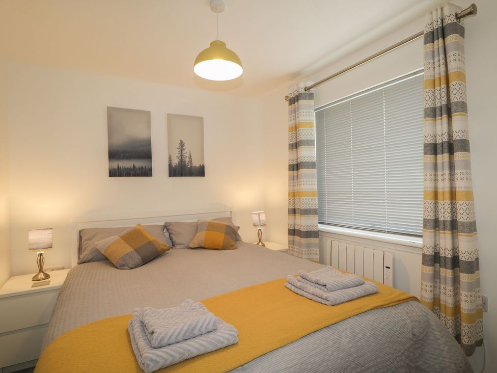 A bedroom with a bed and bedside lamps at The Cairn