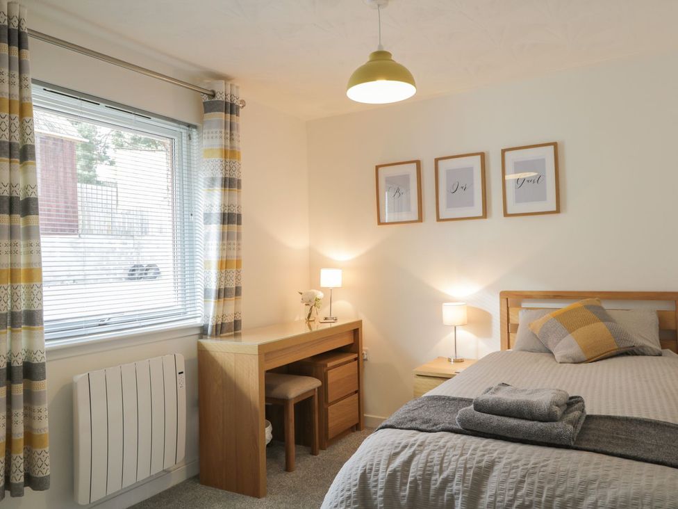 A bedroom with a bed and desk at The Cairn in 