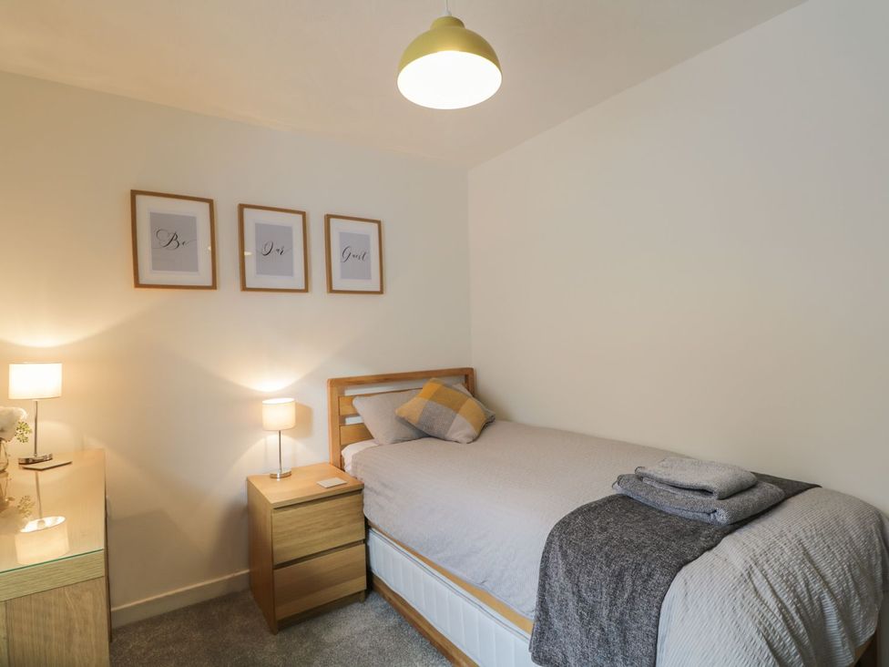 A bedroom with a bed and bedside lamp at The Cairn 