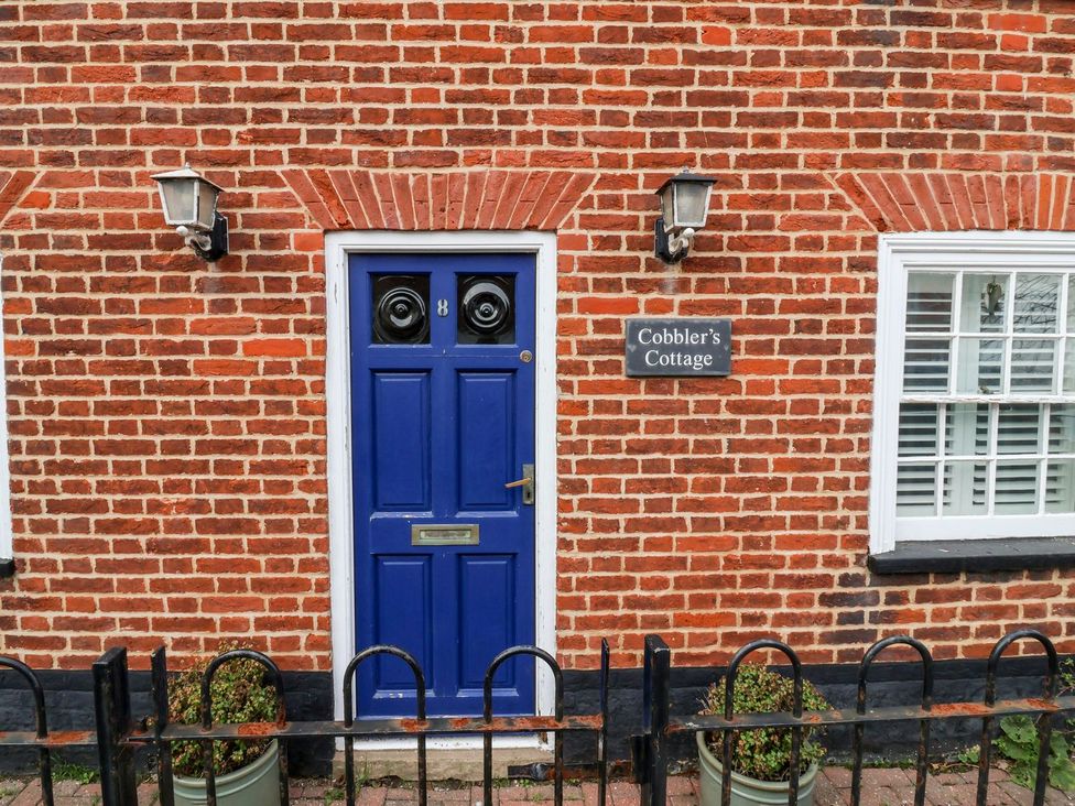 A blue door with a nameplate at Cobblers Cottage in Southwold