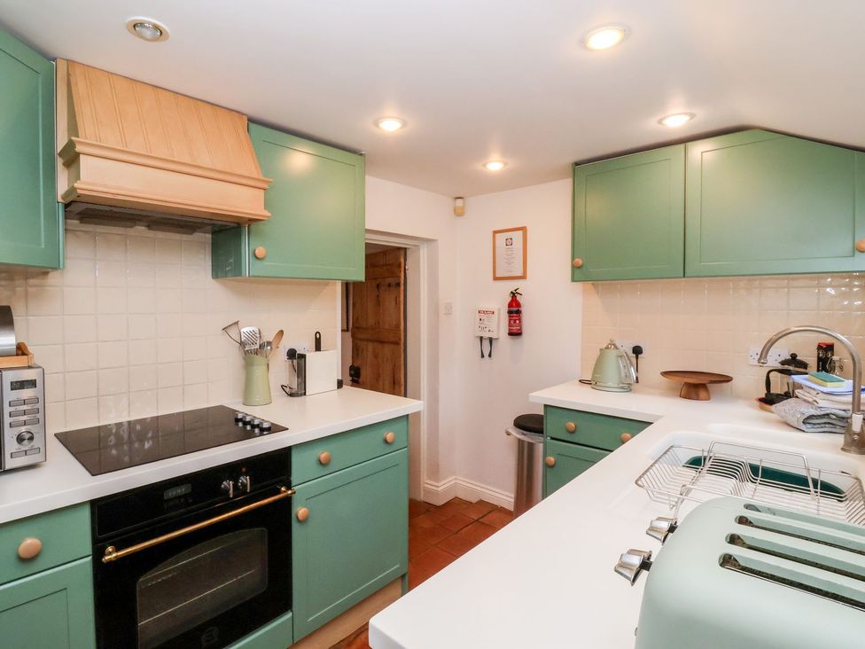 A kitchen with appliances and cabinets at Cobblers Cottage in Southwold
