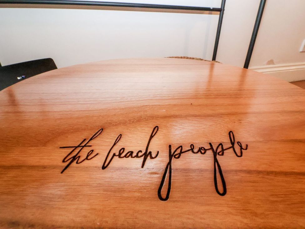 A wooden table with text 'the beach people' at Cobblers Cottage in Southwold