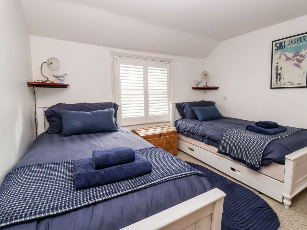 A bedroom with twin beds and a window at Cobblers Cottage in Southwold