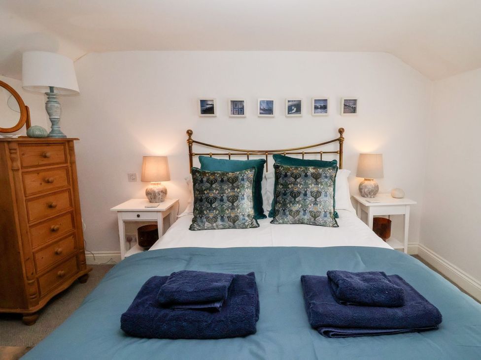 A bedroom with a bed and bedside tables at Cobblers Cottage Southwold