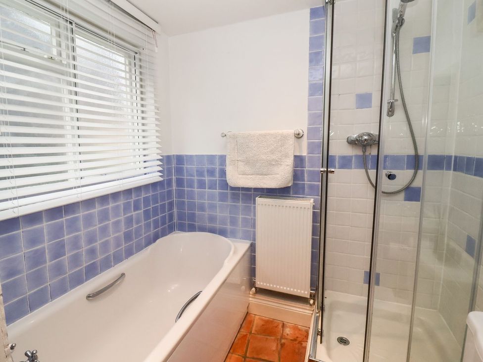 A bathroom with a bathtub and shower at Cobblers Cottage Southwold