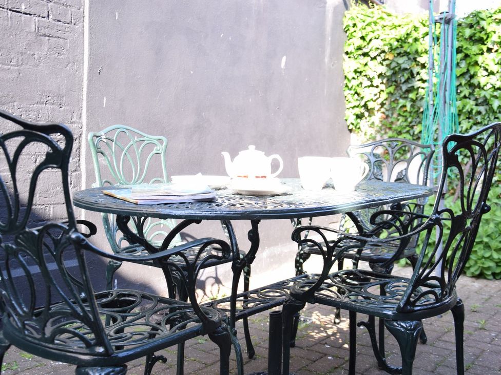 A table with chairs and a teapot at Cobblers Cottage in Southwold