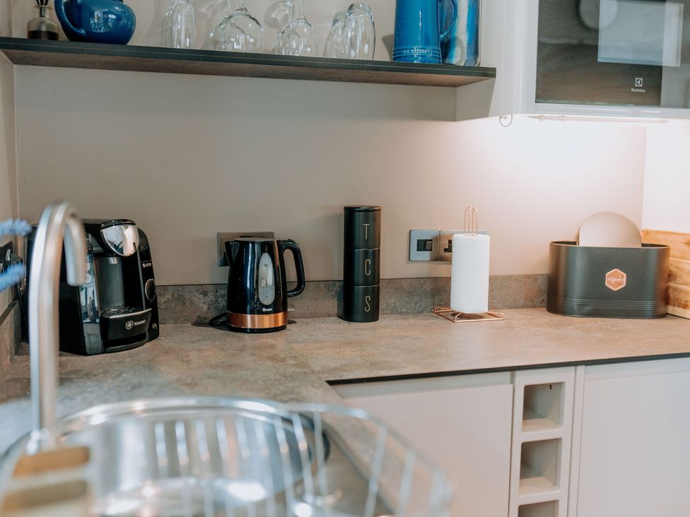 A kitchen countertop with appliances and storage at TyCosy St Davids