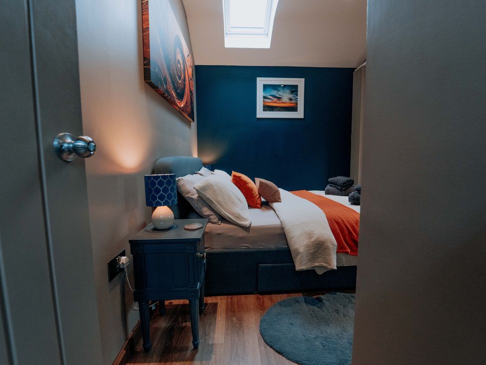 A bedroom with a bed and bedside table at TyCosy in St Davids