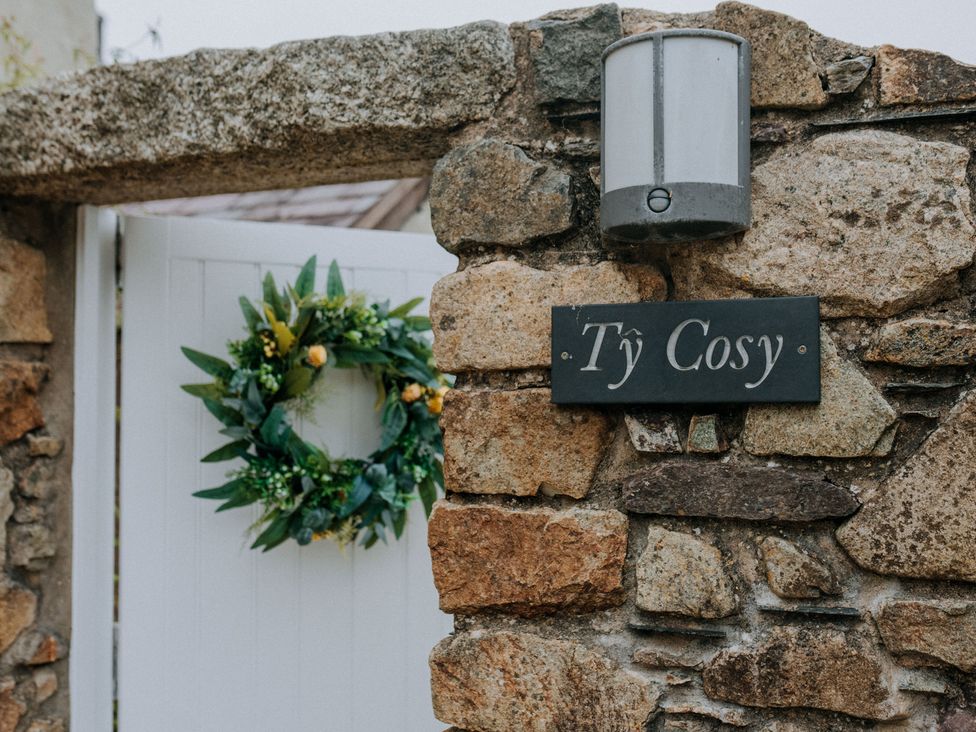 An outdoor entrance with a stone wall and gate at Ty Cosy in St Davids
