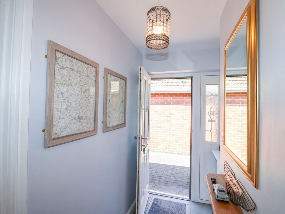 A hallway with maps on the wall and a mirror at Pinecote Cottage Nottingham