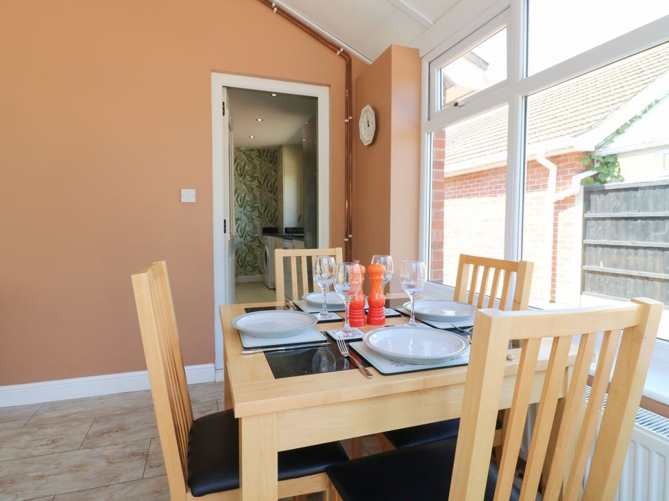 A dining room with a table set for meals at Pinecote Cottage Nottingham