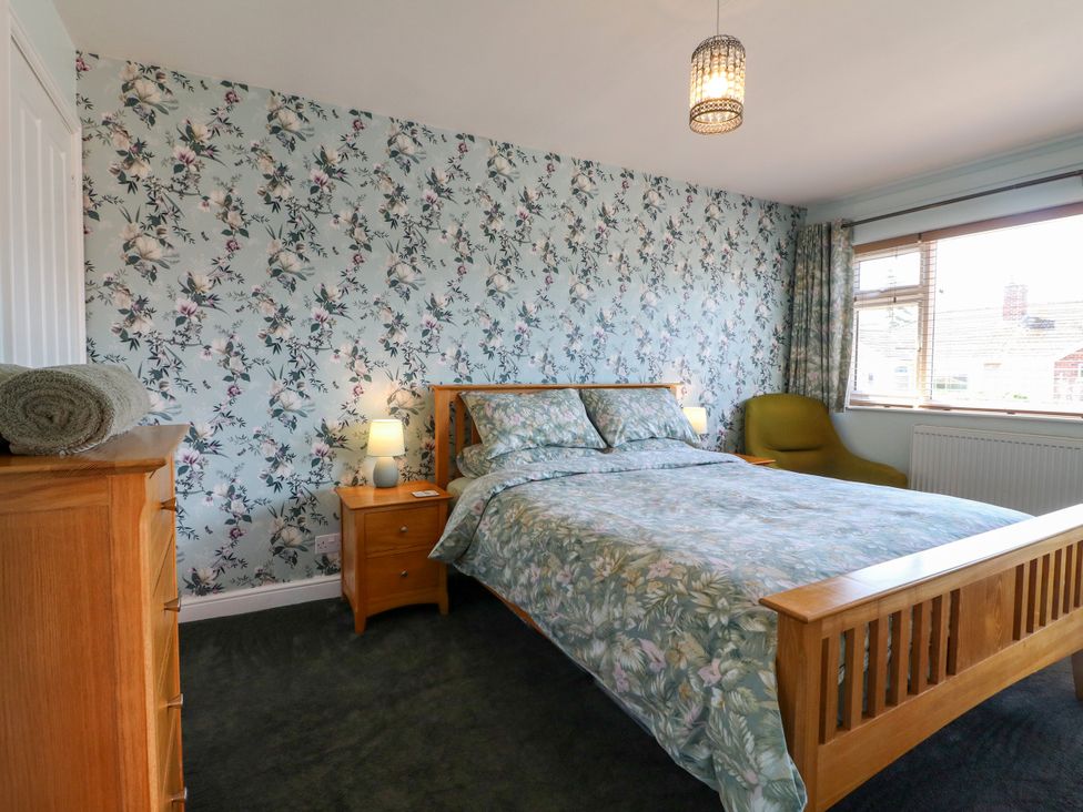 A bedroom with a bed and bedside table at Pinecote Cottage Nottingham