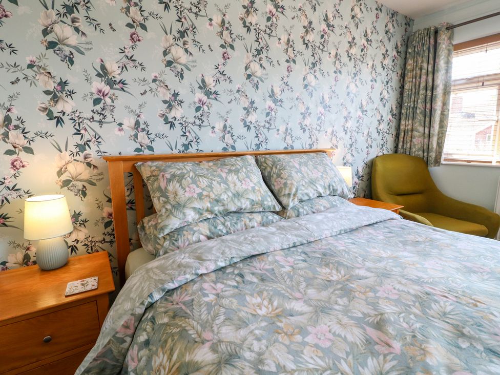 A bedroom with a bed and nightstand at Pinecote Cottage Nottingham