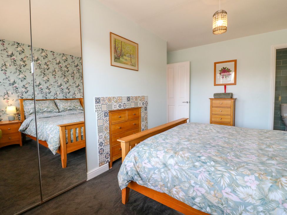 A bedroom with a bed and wardrobe at Pinecote Cottage Nottingham