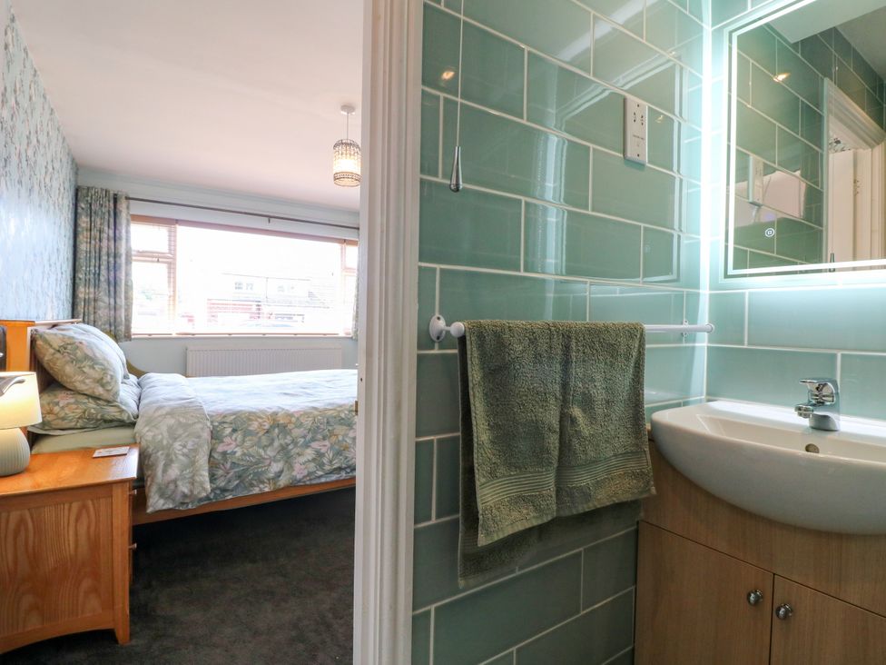 A bedroom with a bed and a bathroom area at Pinecote Cottage Nottingham