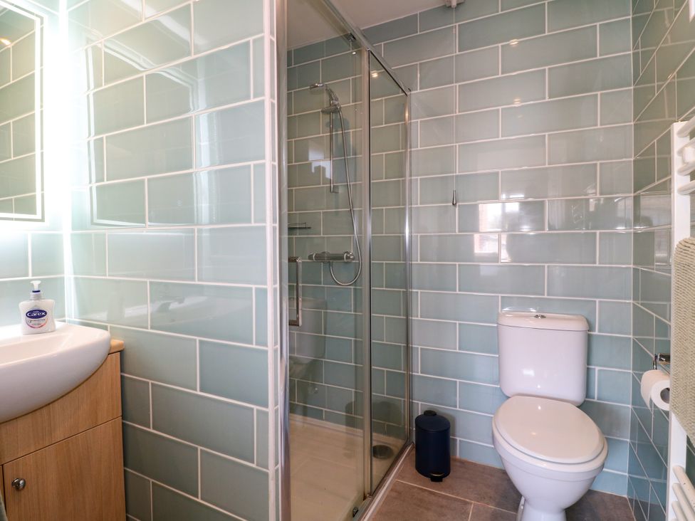 A bathroom with a shower and sink at Pinecote Cottage in Nottingham