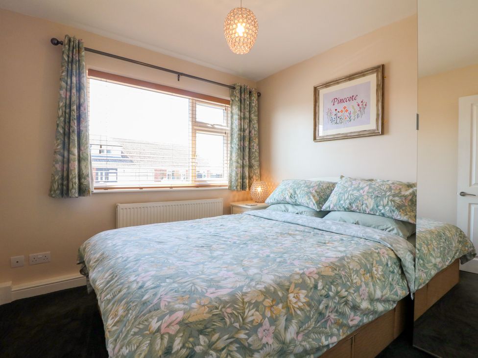 A bedroom with a bed and window at Pinecote Cottage Nottingham
