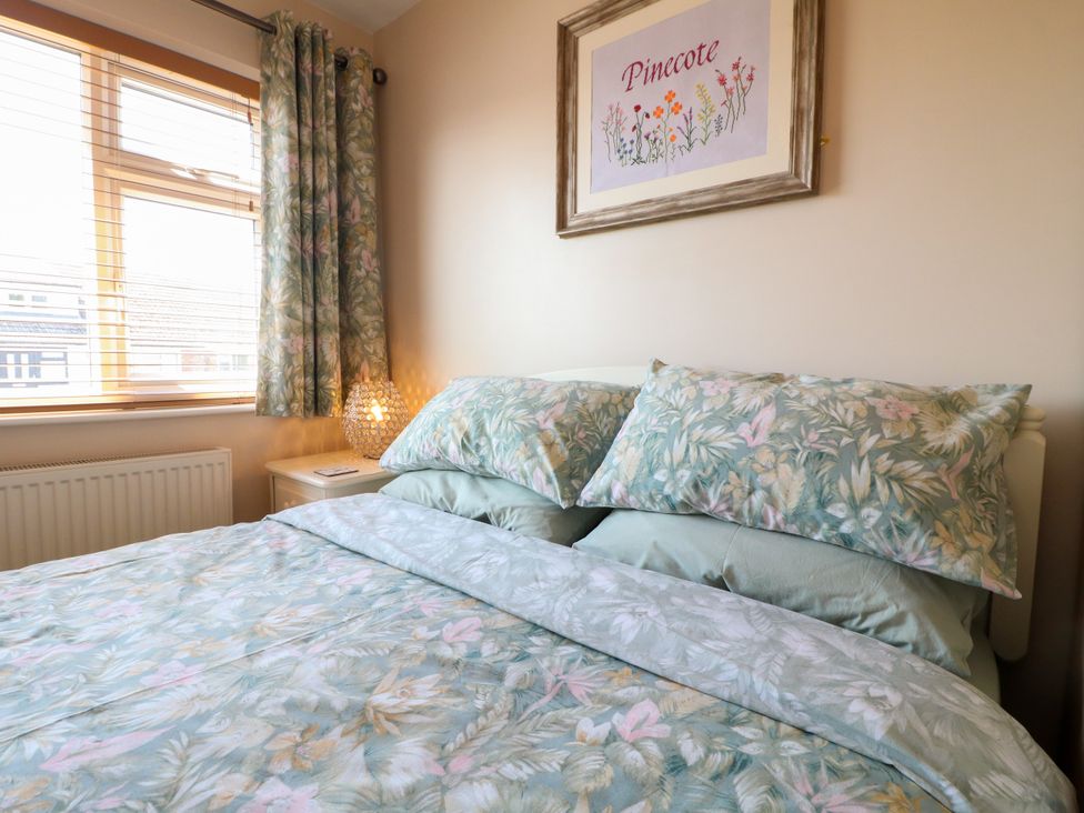 A bedroom with a bed and decorative items at Pinecote Cottage in Nottingham