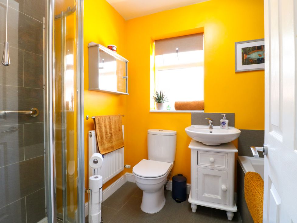 A bathroom with shower, toilet, and sink at Pinecote Cottage Nottingham