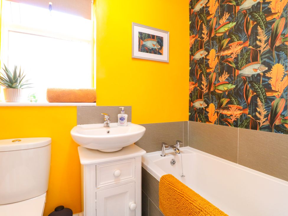 A bathroom with a sink and bathtub at Pinecote Cottage in Nottingham