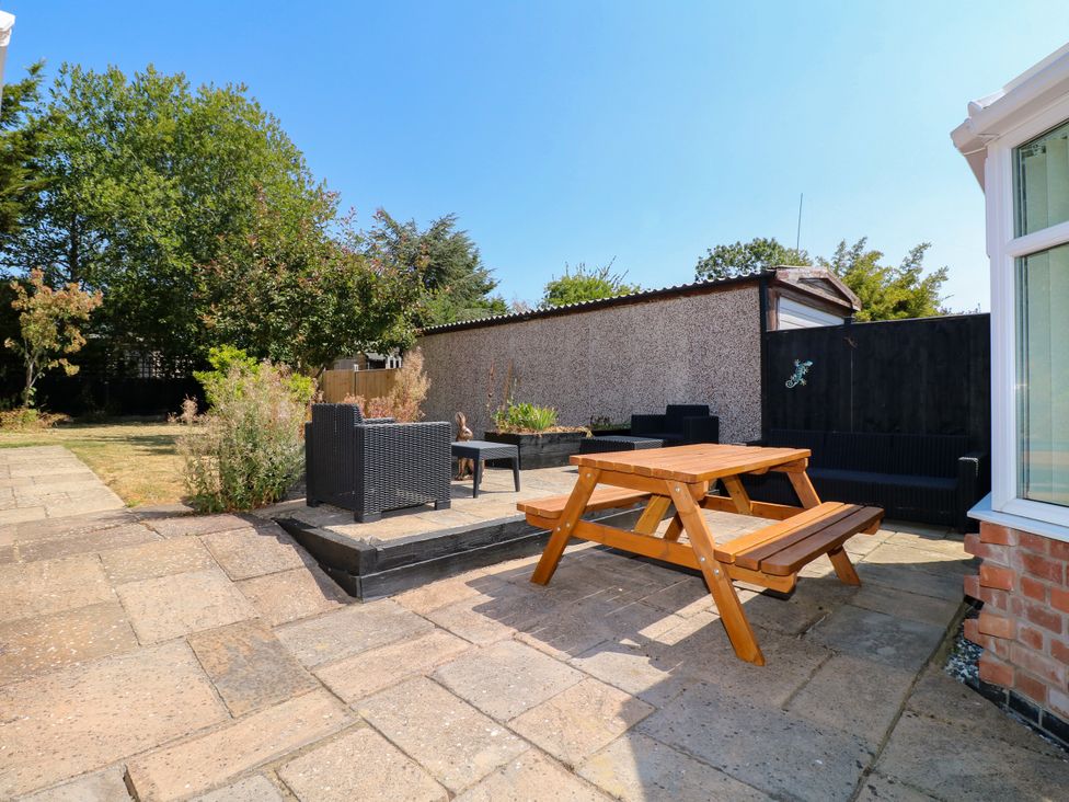 A garden with a picnic table and outdoor seating at Pinecote Cottage in Nottingham