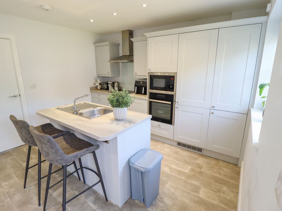 A kitchen with an island, sink, and appliances at Burton Fields in Brandesburton