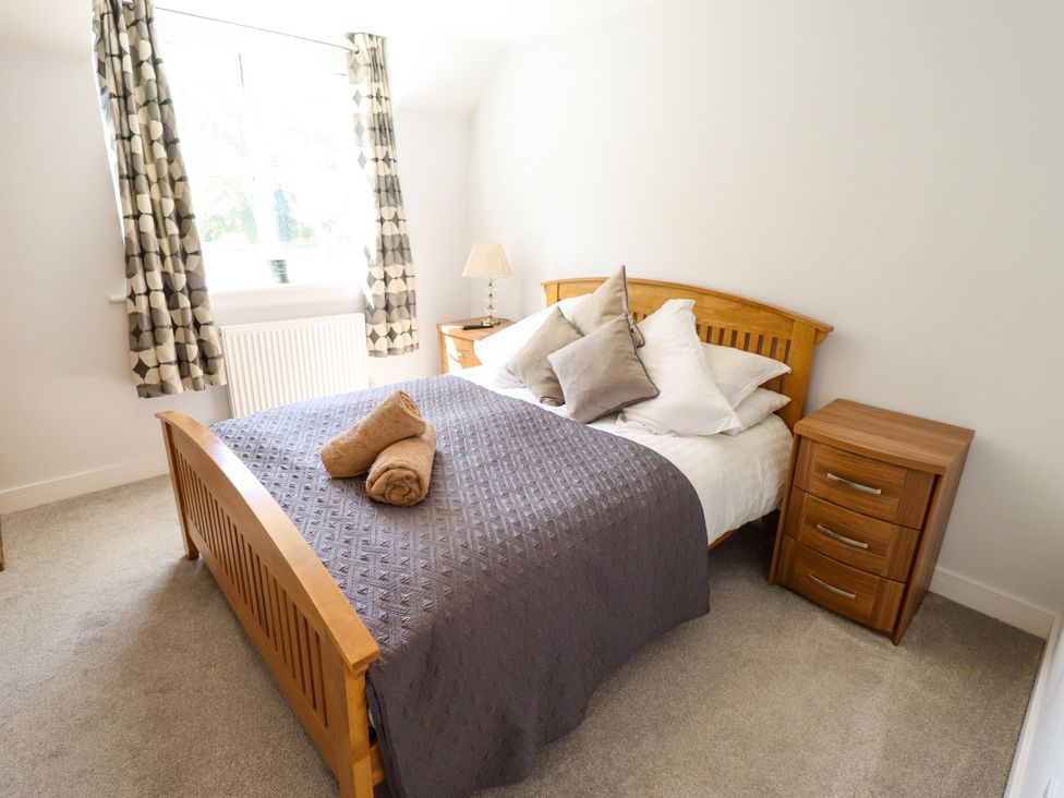 A bedroom with a bed and bedside table at Burton Fields in Brandesburton