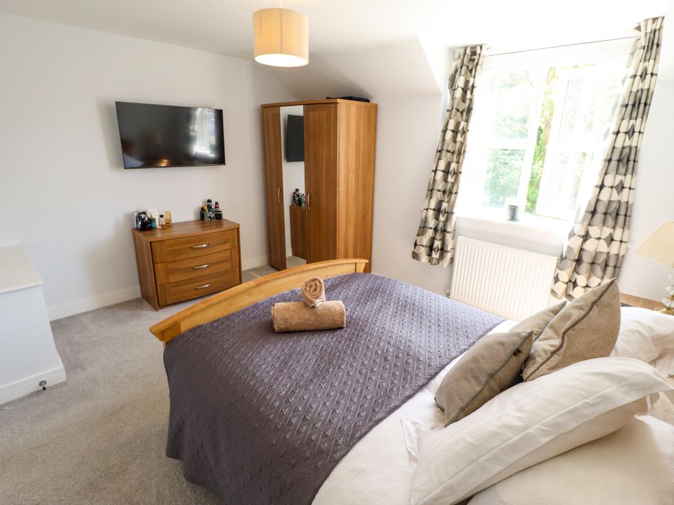 A bedroom with a bed, dresser, wardrobe and television at Burton Fields in Brandesburton