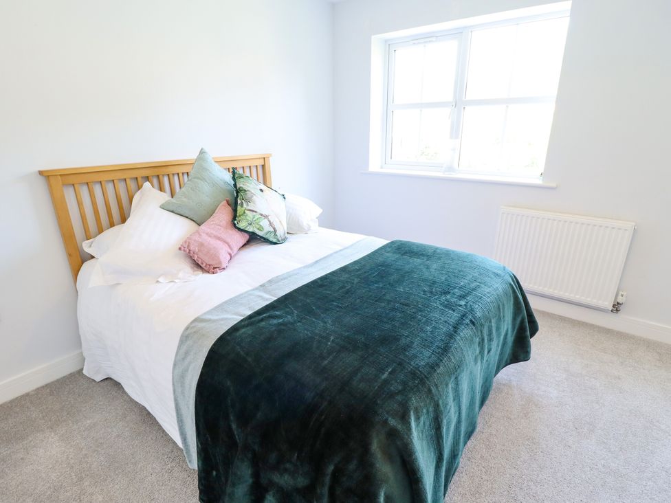 A bedroom with a bed and window at Burton Fields in Brandesburton