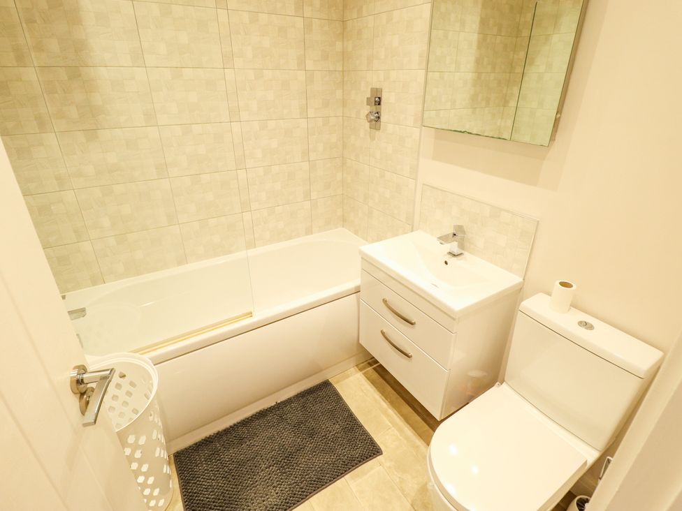 A bathroom with a bath tub, sink, and toilet at Burton Fields in Brandesburton