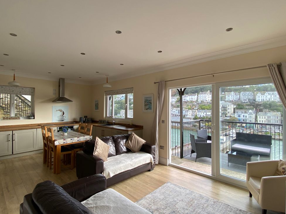 A living room with a dining area and kitchen at Rivercrest in Looe
