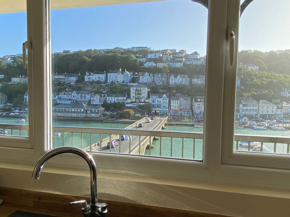 A kitchen with a view of a bridge and houses at Rivercrest in Looe