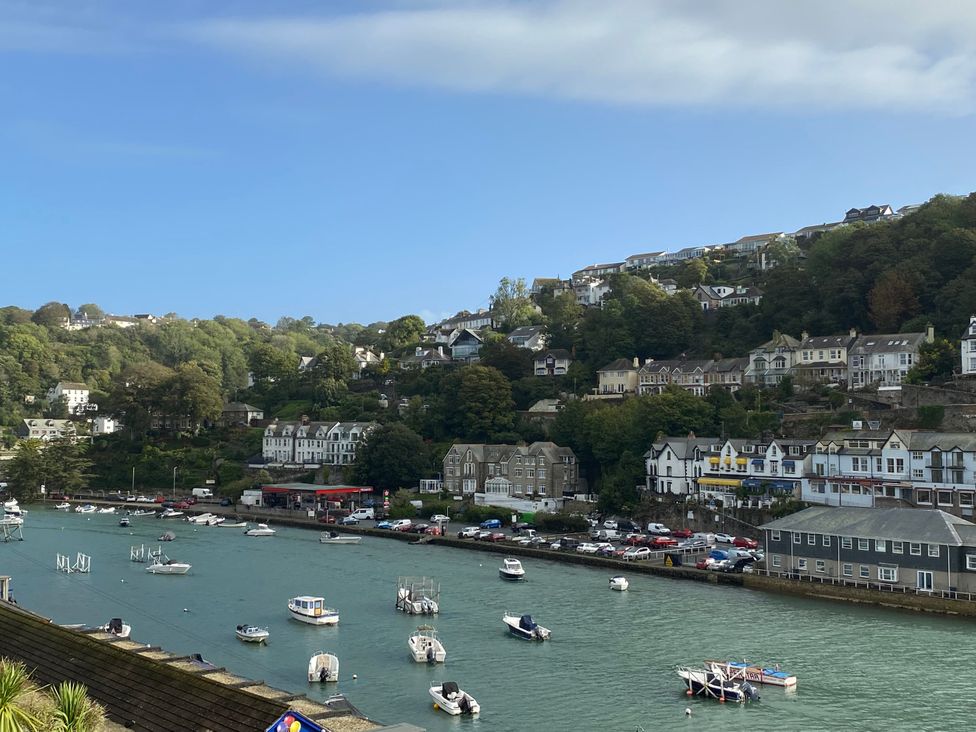 A view of boats on the water with houses on the hillside at Rivercrest in Looe