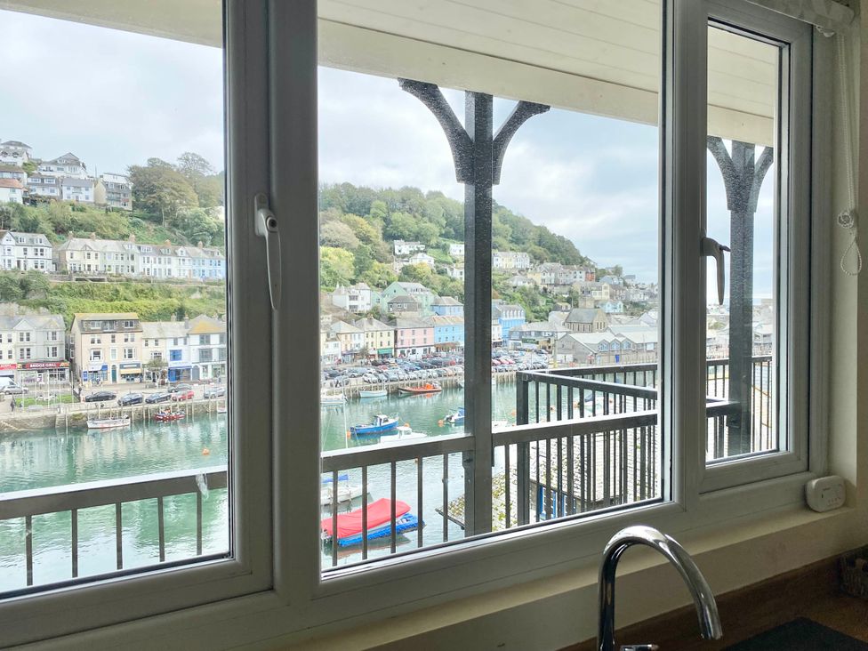 A view of a harbor with boats and buildings from a kitchen at Rivercrest in Looe