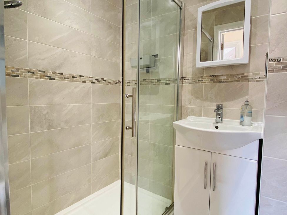 A bathroom with a shower and sink at Rivercrest in Looe