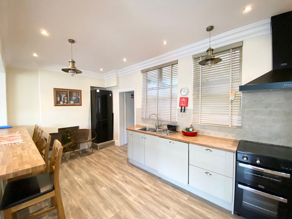 A kitchen with a refrigerator and sink at Nesden House 