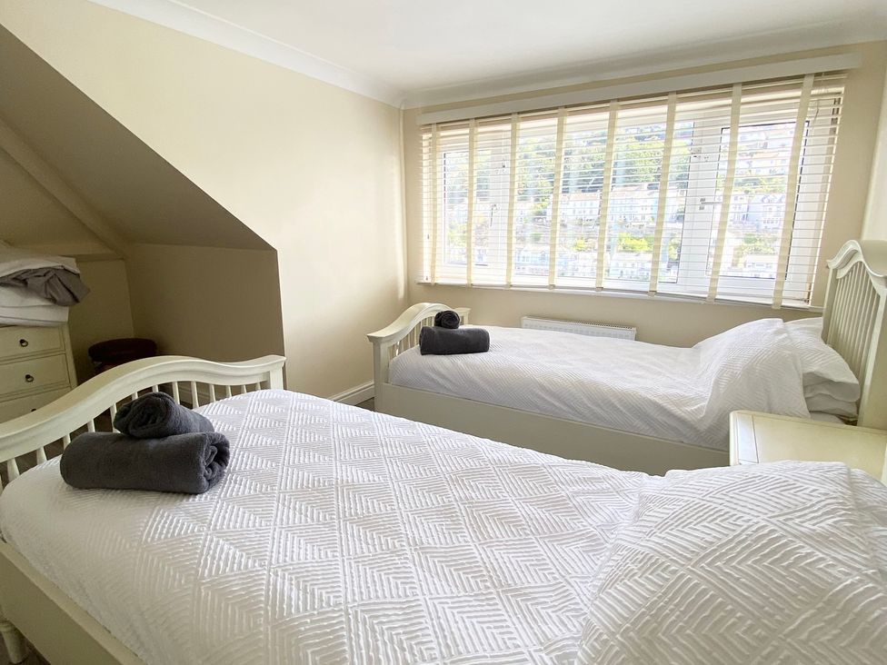 A bedroom with two beds and a dresser at Nesden House