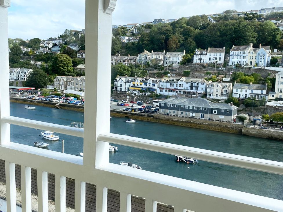 A river with boats and buildings along the shore at Nesden House