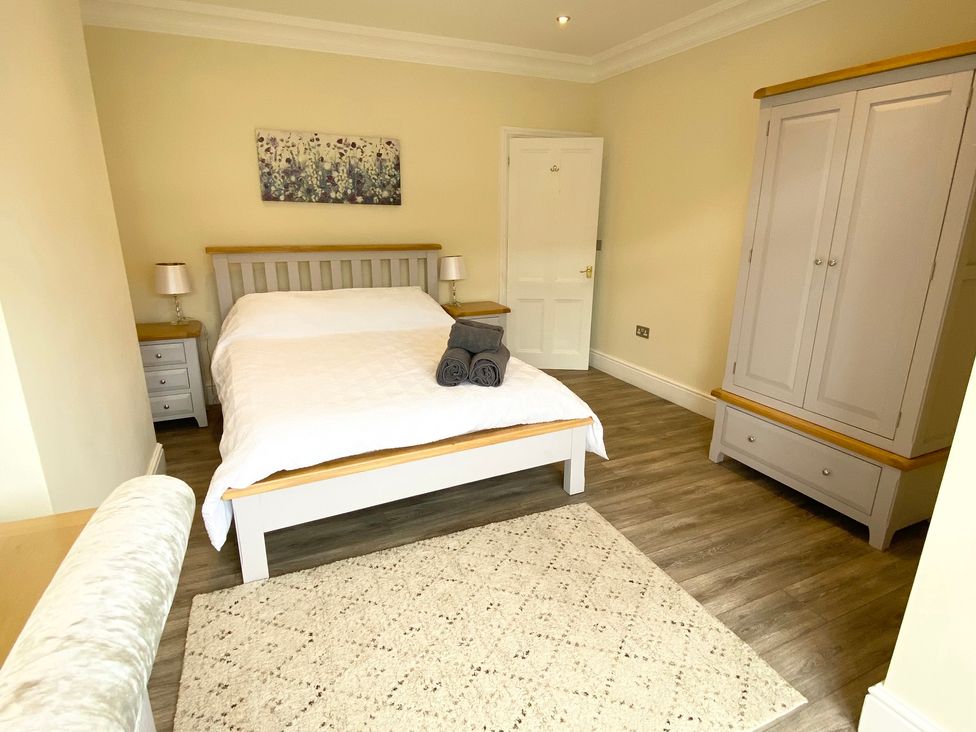 A bedroom with a bed and wardrobe at Nesden House