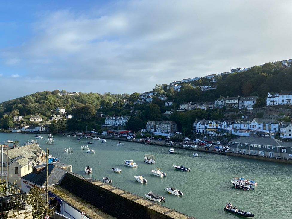 A view of boats on a river with houses and hills at Harbour Lodge in Looe