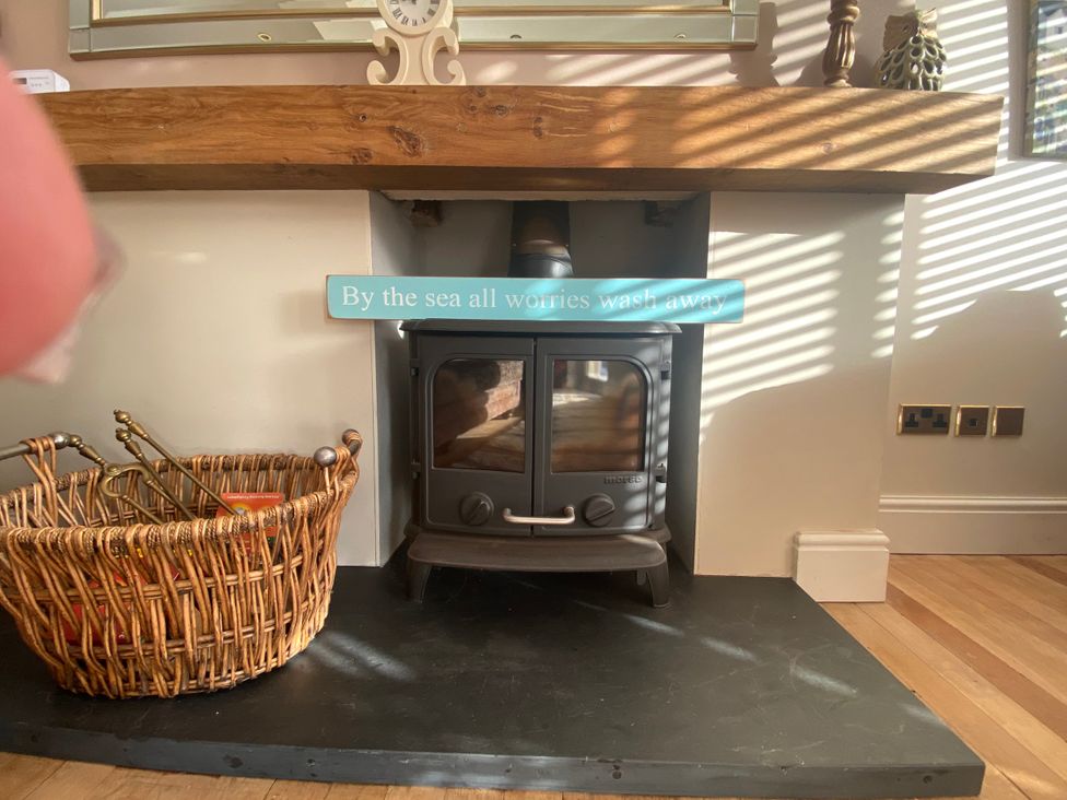 A fireplace with a basket and fire tools at Harbour Lodge in Looe