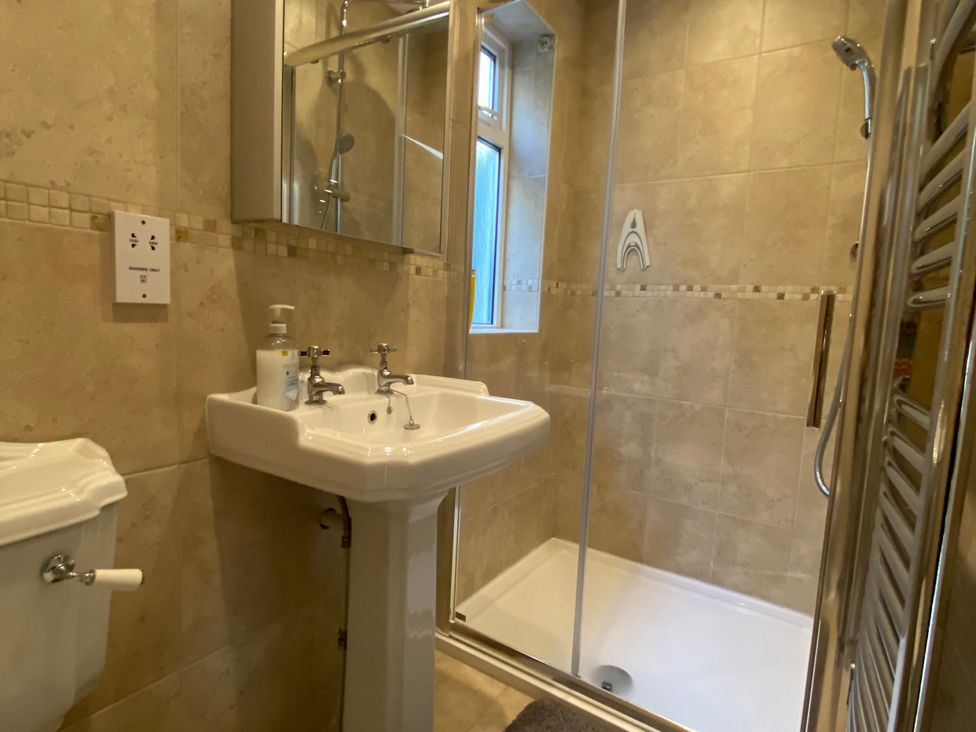 A bathroom with sink, toilet, and shower at Harbour Lodge in Looe