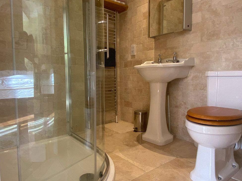 A bathroom with a shower, sink, and toilet at Harbour Lodge in Looe