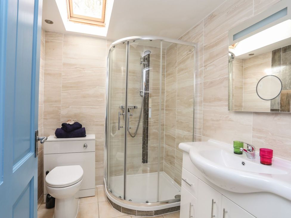 A bathroom with a shower and sink at Riverside Cottage in Caernarfon