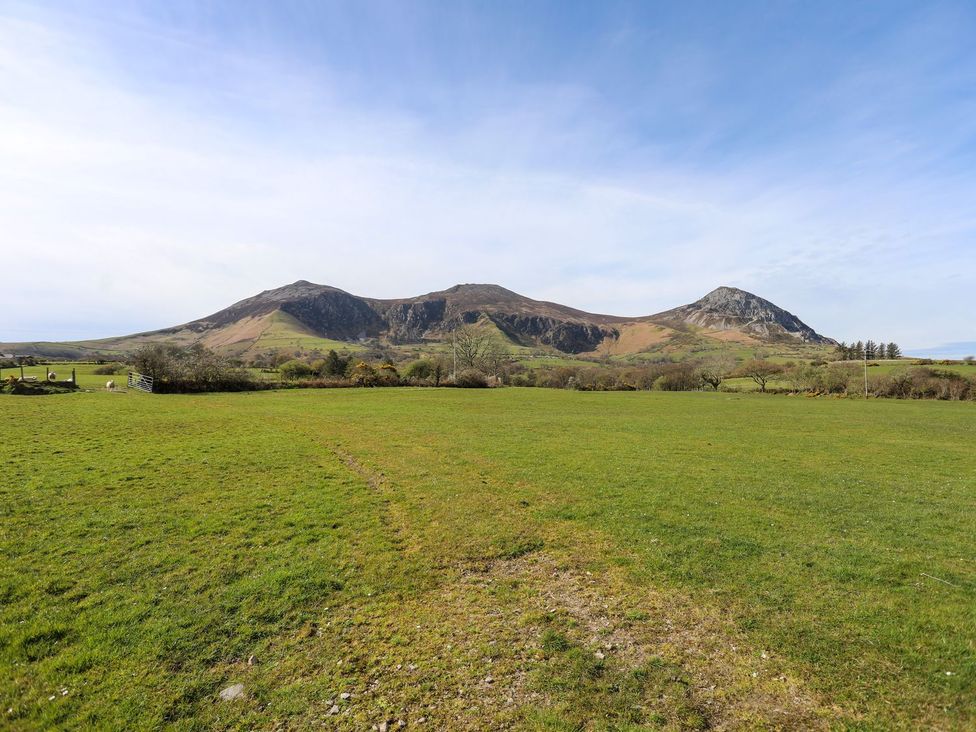 A landscape view of mountains and grass fields at Riverside Cottage in Caernarfon