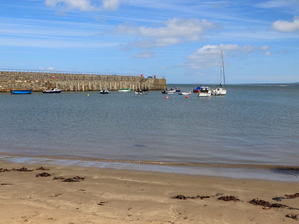 A coastal scene with boats near a pier at Riverside Cottage in Caernarfon