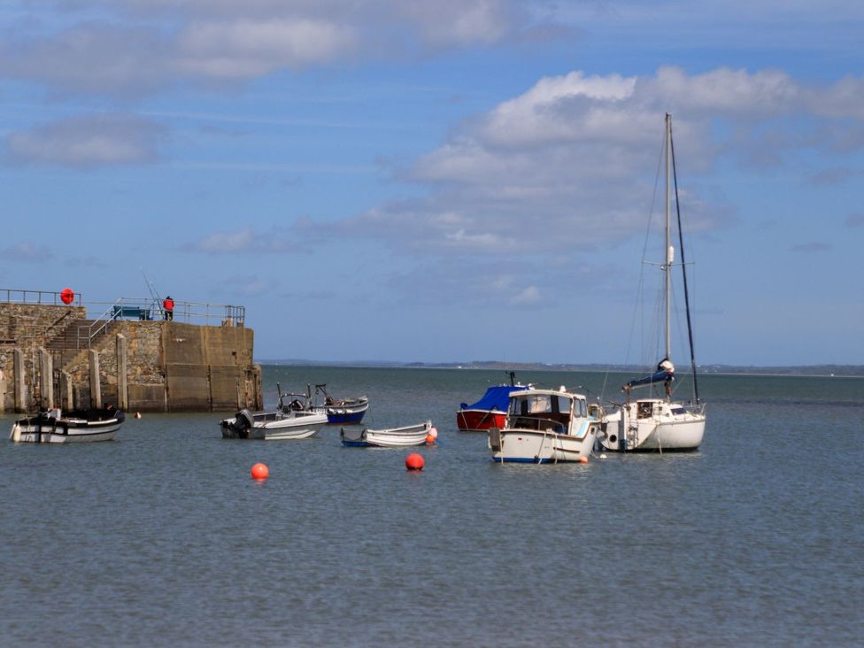 A view of boats at a pier on water at Riverside Cottage in Caernarfon