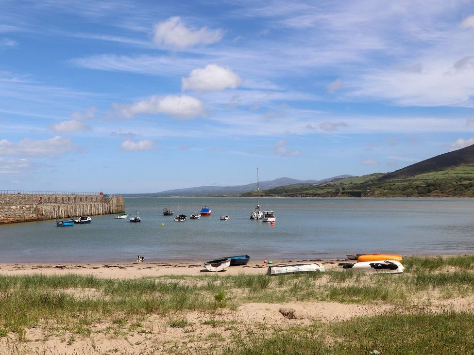 A beach with boats on water at Riverside Cottage in Caernarfon