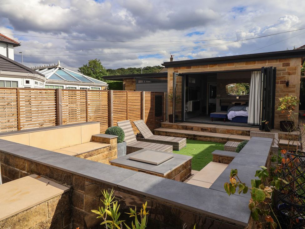 A garden with seating and a view of the building at The Annexe in Shipley