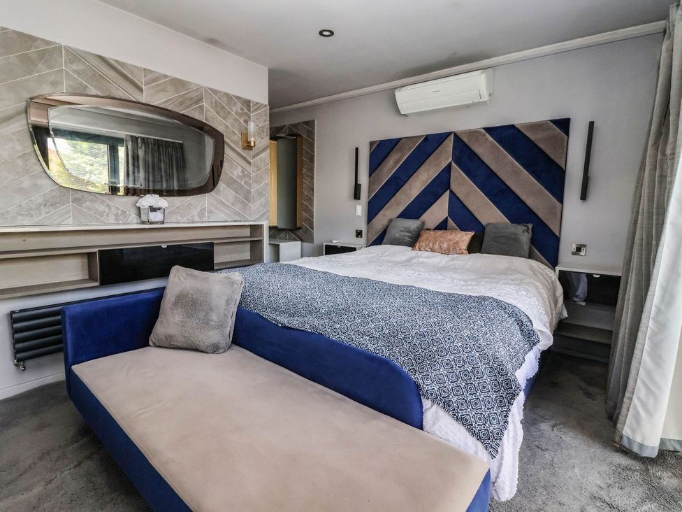 A bedroom with a bed and a mirror at The Annexe in Shipley